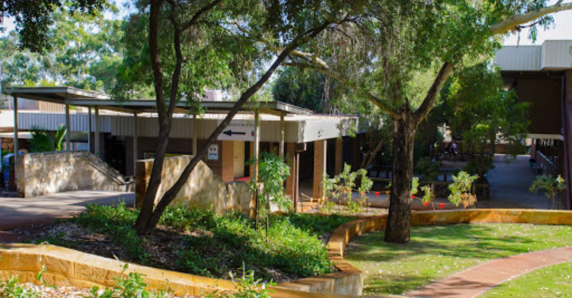 L'area esterna verde con un sentiero e circondata da alberi nel campus del Greenwood College.