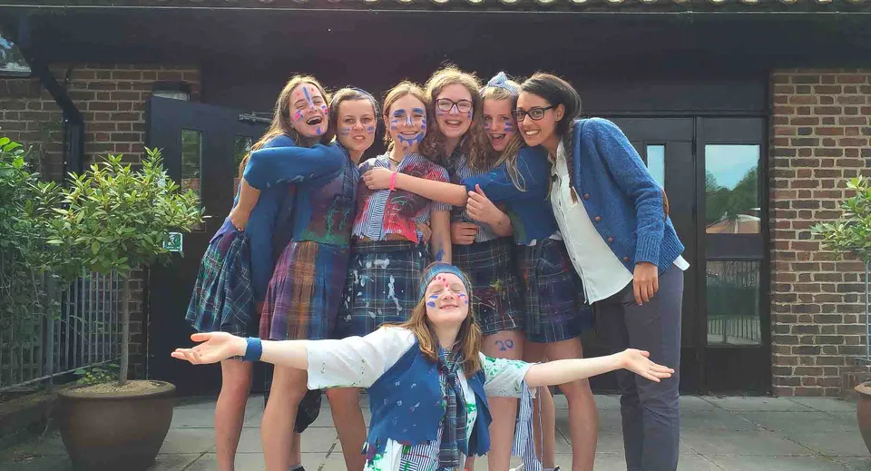 Un gruppo di studentesse è davanti a un edificio in mattoni nel campus della St. Swithun's School.