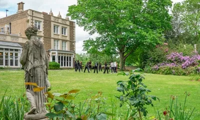 La Mansion House del campus di Avery Hill con la statua nel giardino e il grande prato alberato