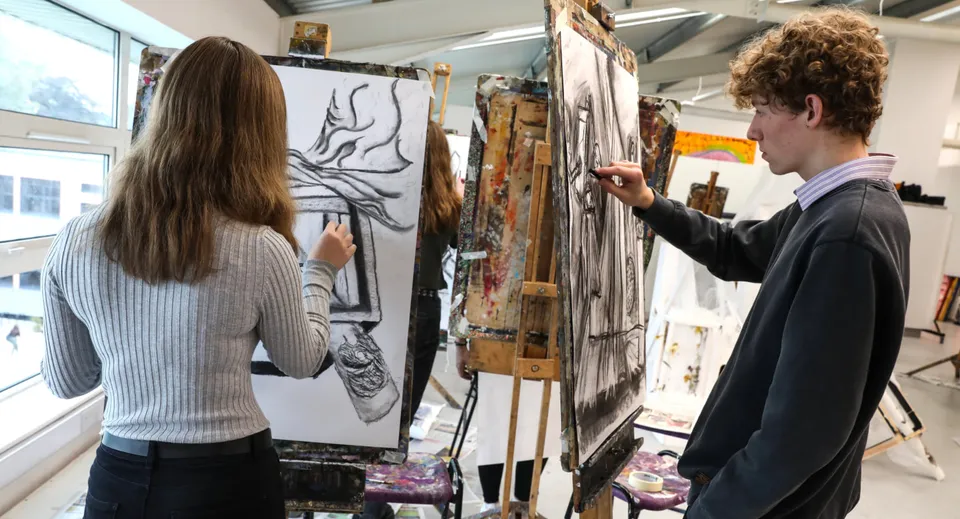 Due persone osservano opere d'arte in un atelier nel campus di Queen Elizabeth’s 6th Form.