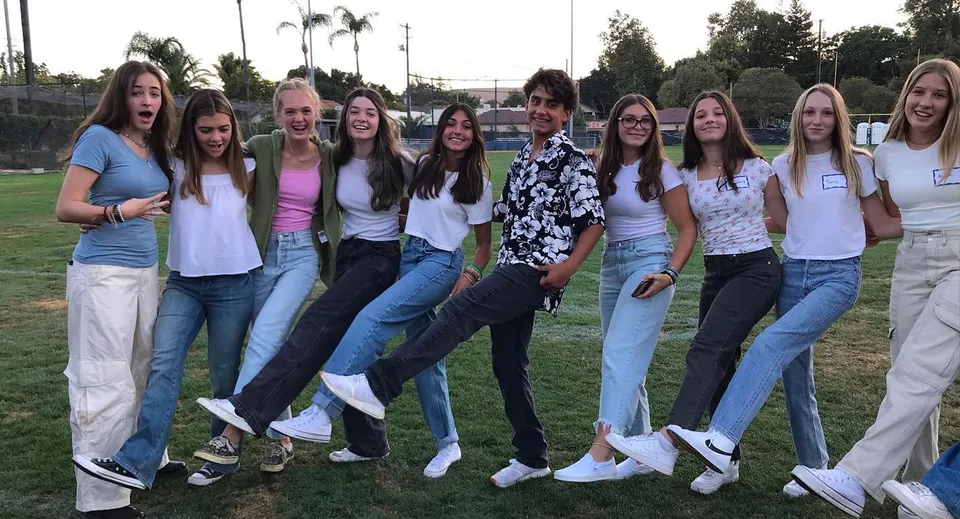 Un gruppo di studentesse si trova su un prato con palme nella proprietà della Mission College Preparatory Catholic High School.