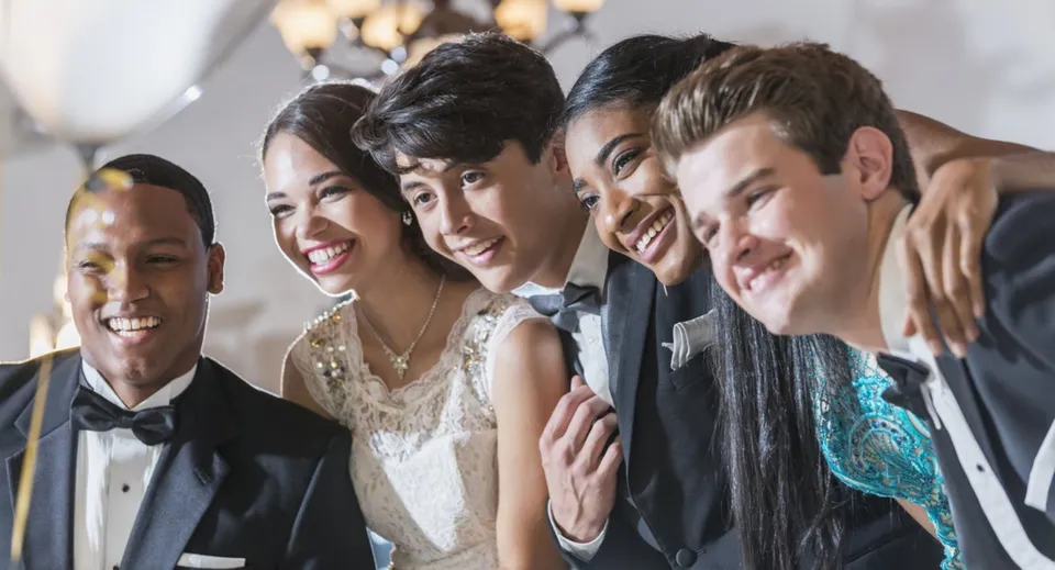 Un gruppo di persone posa sorridente a una festa al Wycliffe College.