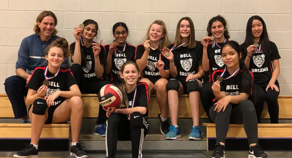La squadra di pallavolo della Bell High School posa insieme nella palestra.