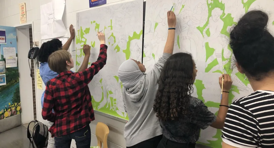 Studenti della Merivale High School lavorano insieme a un murale colorato con elementi artistici.