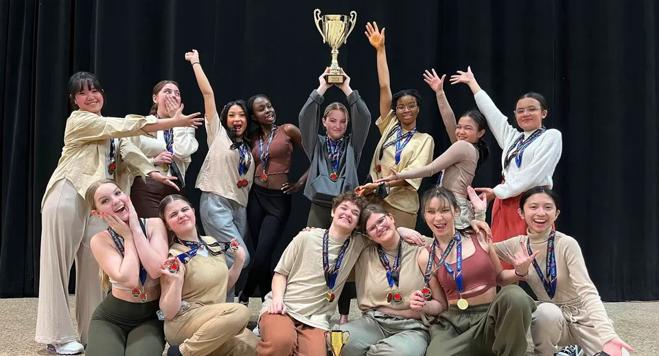 Studentesse del Kildonan East Collegiate festeggiano sul palco tenendo un trofeo durante la cerimonia di premiazione.