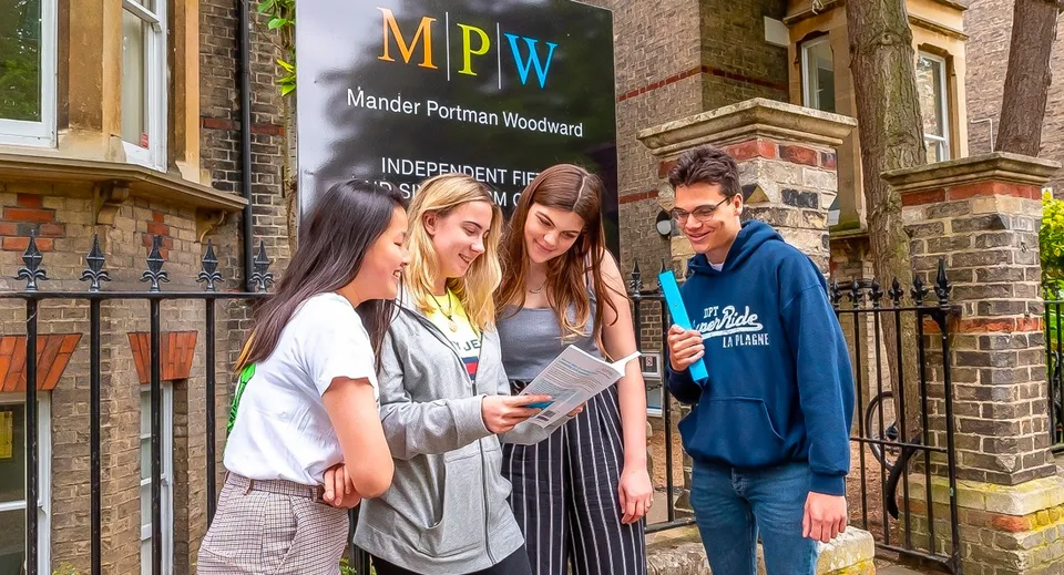 Un gruppo di studenti si trova davanti all'edificio della MPW Birmingham e conversano tra loro.