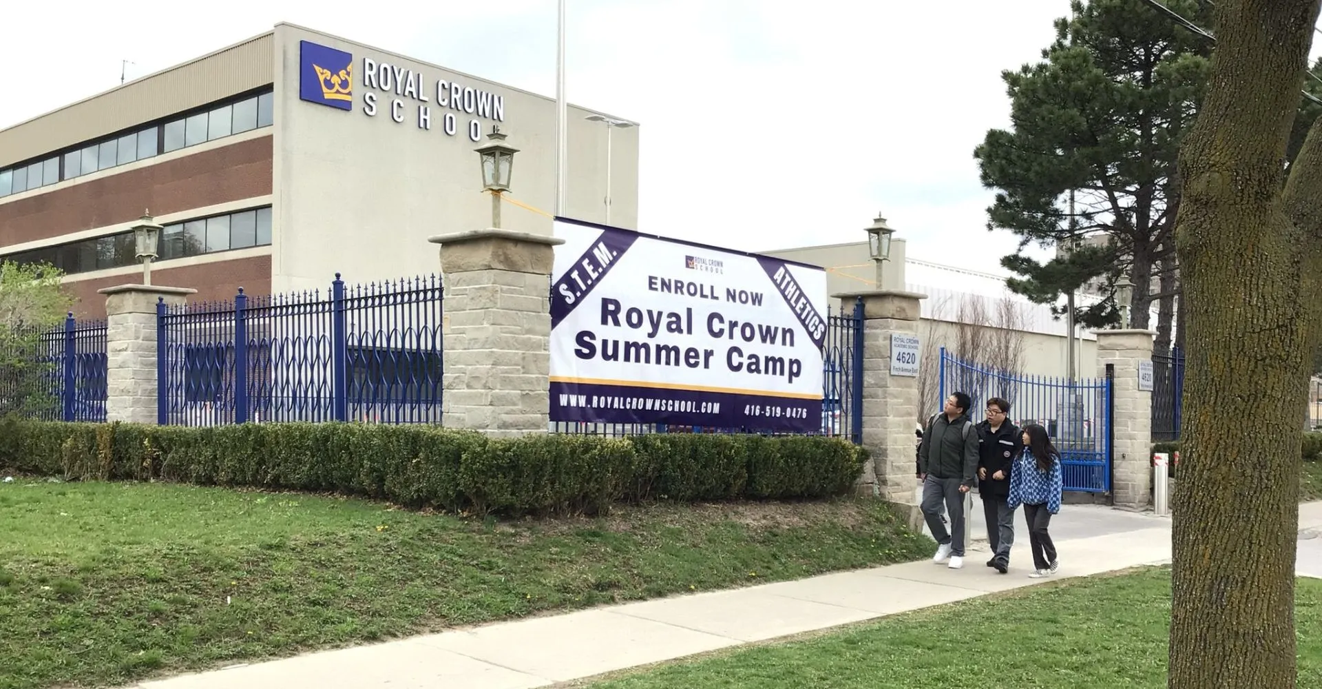 L'edificio della Royal Crown School con l'insegna Royal Crown Summer Camp e persone sul marciapiede davanti.