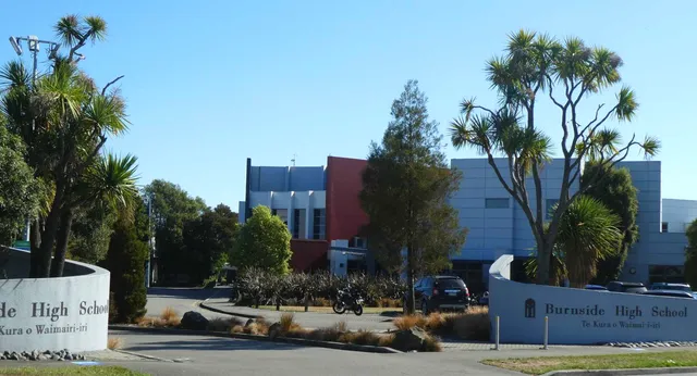 Der Campus der Burnside State High School mit Palmen und einem modernen mehrstöckigen Gebäude im Hintergrund.