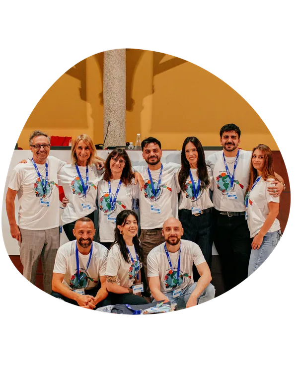Team di consulenti in maglietta coordinata posa sorridente insieme a un evento