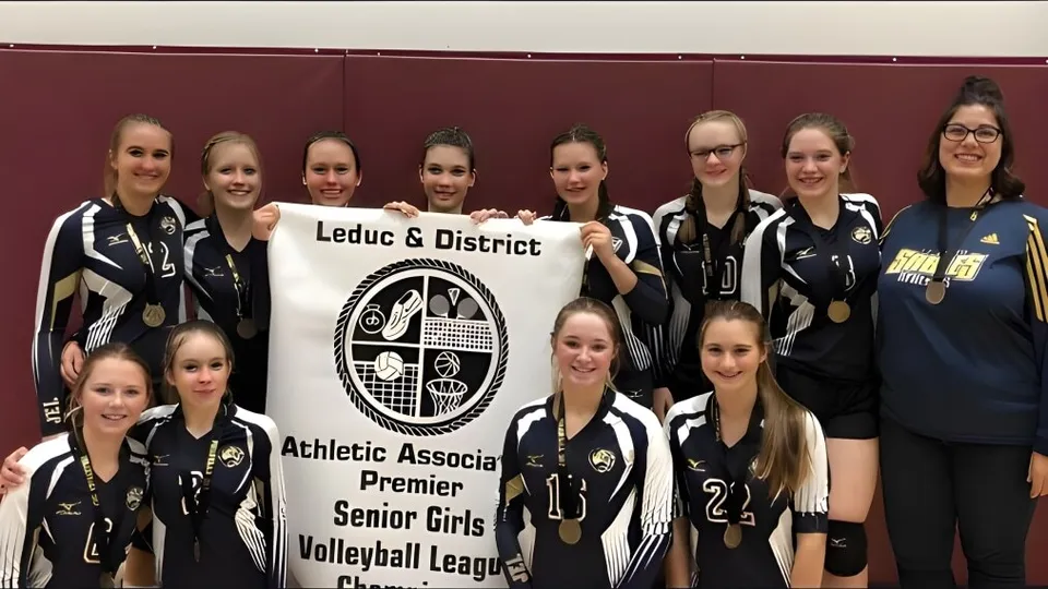 Un gruppo di giocatrici di pallavolo della École J.E. Lapointe School posa insieme a uno striscione della Leduc & District Athletic Association Premier Senior Girls Volleyball League.