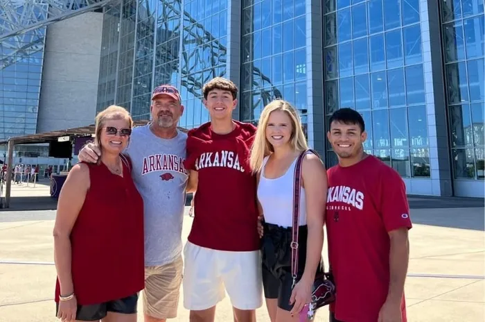 Martí y su familia anfitriona, con camisetas de Arkansas, delante de un gran estadio