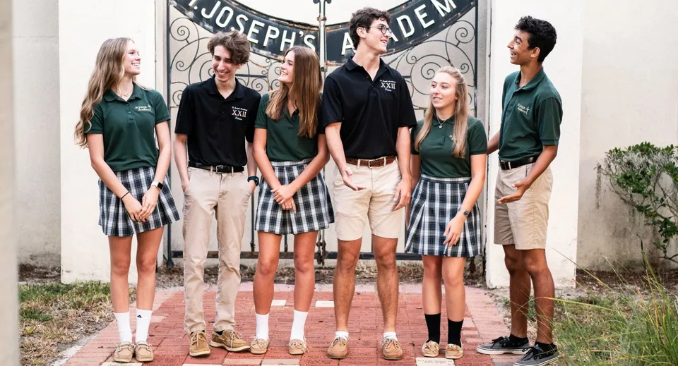 Un gruppo di studenti si trova davanti all'edificio della St. Joseph Academy con la scritta Joseph's Den.