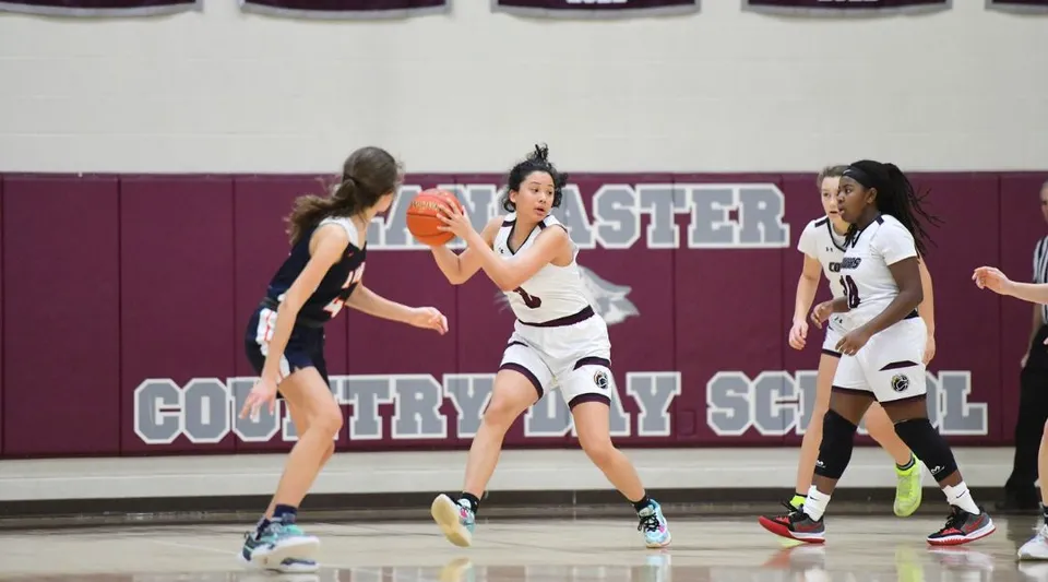 Studentesse giocano a basket sul campo sportivo della Lancaster Country Day School.
