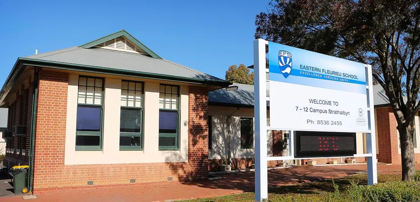 L'edificio in mattoni con il tetto verde nel campus della Eastern Fleurieu R-12 è circondato da alberi.