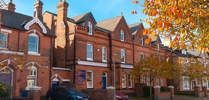 L'edificio in mattoni a più piani con architettura decorata della MPW Birmingham è circondato da un variopinto fogliame autunnale.