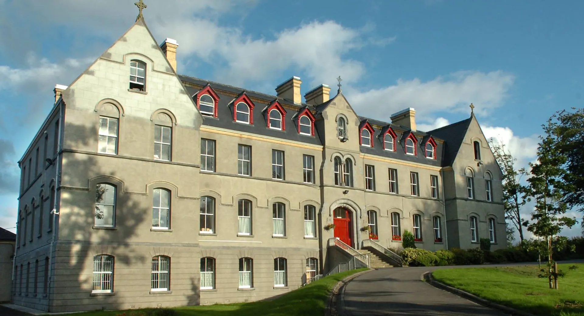 L'edificio principale a più piani del St. Muredach's College è circondato da una verde vegetazione.