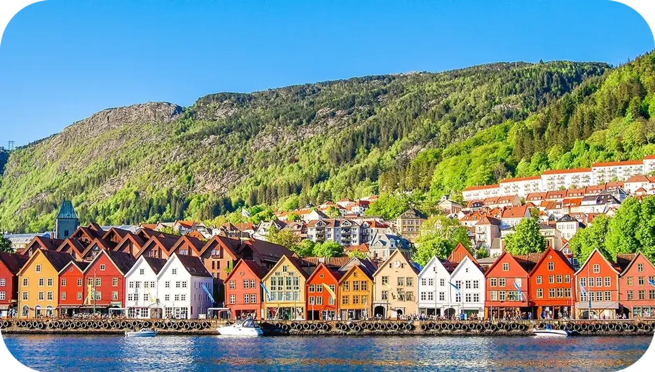 Case di legno colorate lungo il molo di una città portuale norvegese ai piedi di una collina