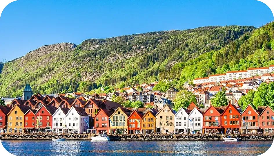 Case di legno colorate lungo il molo di una città portuale norvegese ai piedi di una collina