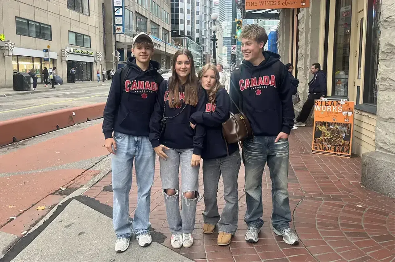 Quattro studenti con felpe Canada in una strada cittadina