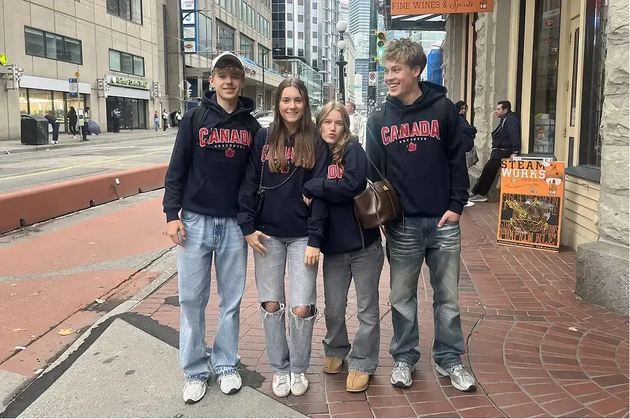 Quattro studenti con felpe Canada in una strada cittadina