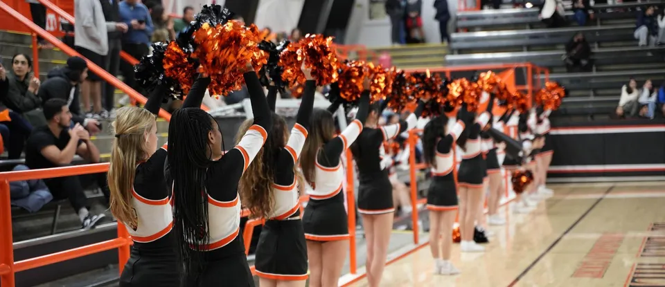 Le divise da cheerleader della Beverly High School con i pompon sono pronte in un'arena sportiva.