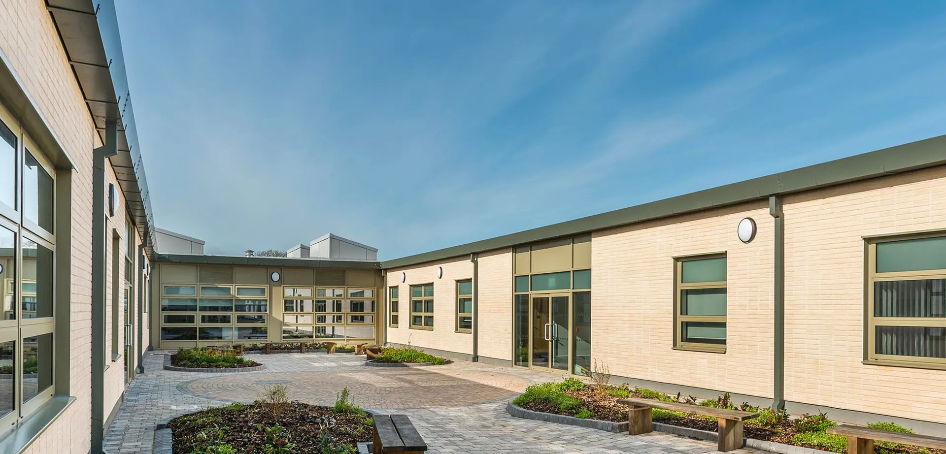 Il cortile interno con un viale lastricato e moderni edifici in mattoni nel campus della Somerset Studio School.