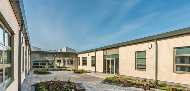 Il cortile interno con un viale lastricato e moderni edifici in mattoni nel campus della Somerset Studio School.