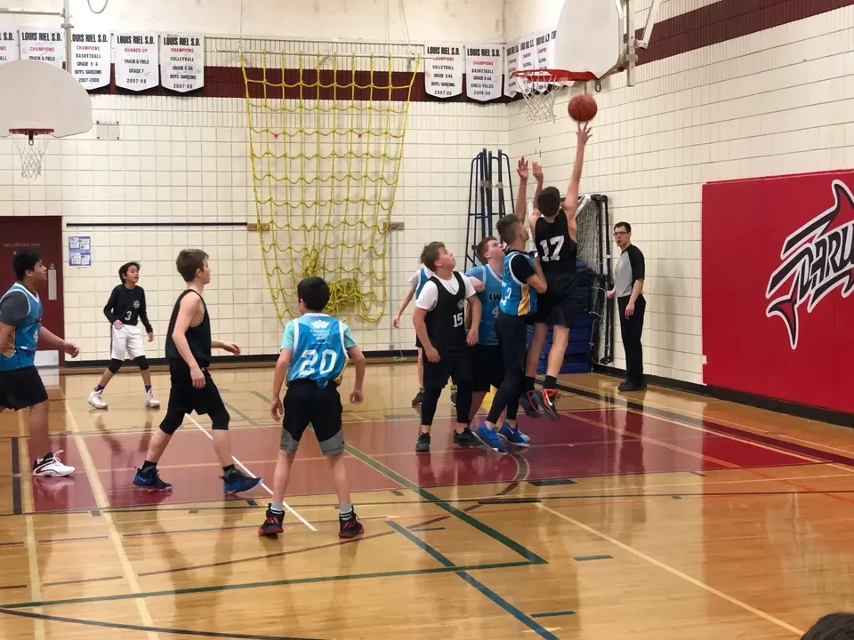 Un gruppo di studenti gioca a basket sul campo sportivo della École secondaire publique Louis-Riel.