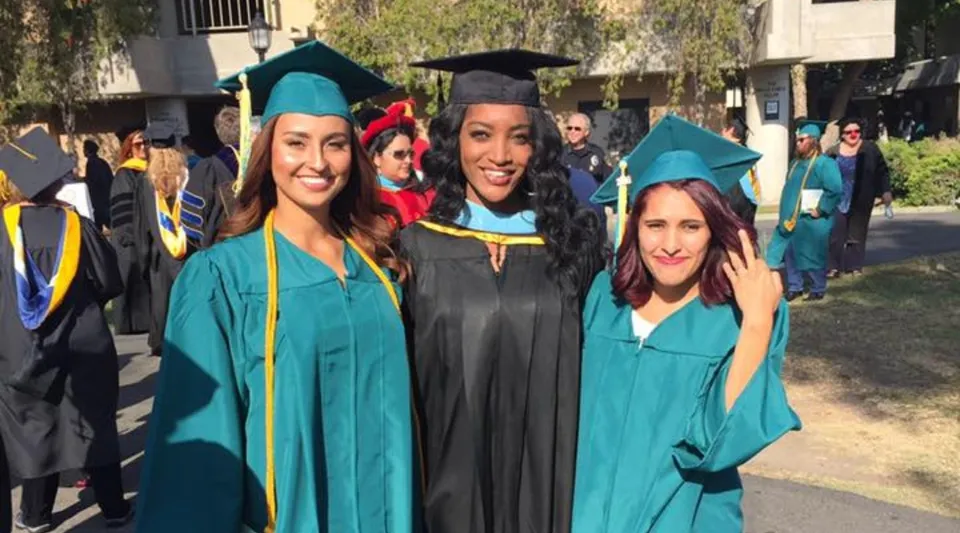 Un gruppo di diplomati in toga verde e nera festeggia il proprio successo al Golden West College.