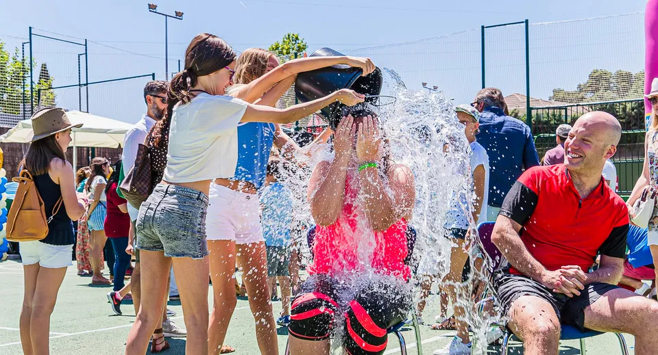 Studenti del King's College giocano e sguazzano insieme nell'acqua nell'area esterna della scuola.