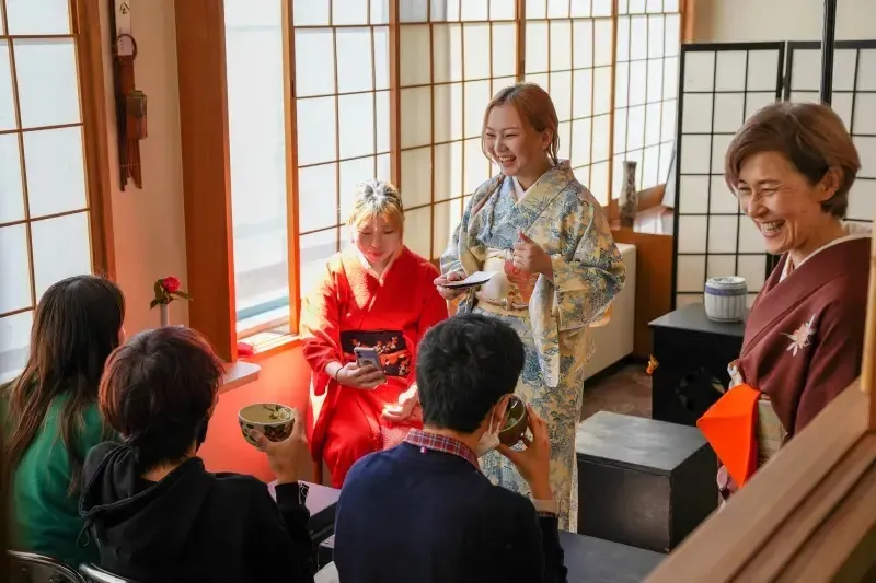 Schüler der Canadian Academy tragen traditionelle japanische Kleidung in einem Raum mit japanischem Dekor.