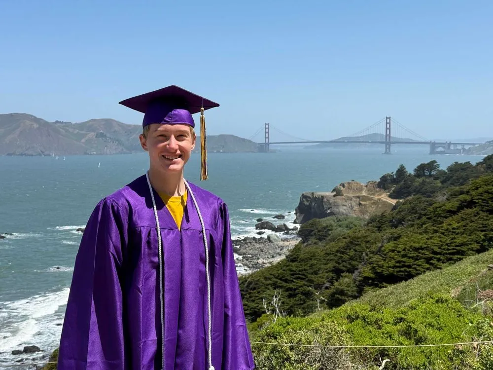 Gastschüler im lila Abschlusstalar vor der Golden Gate Bridge