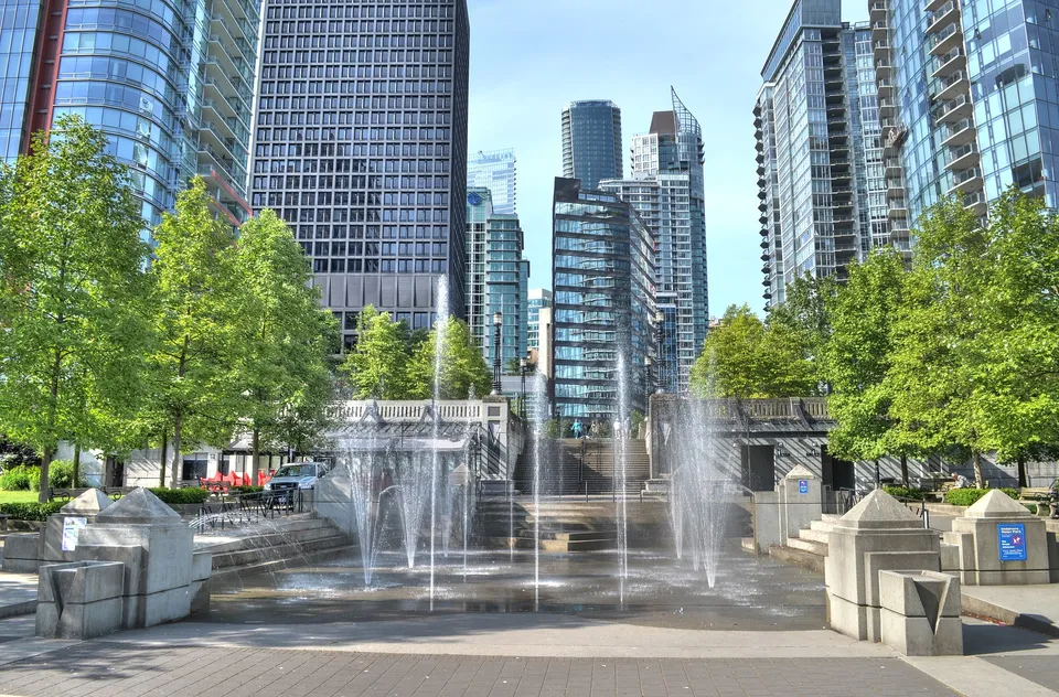 Il paesaggio urbano con grattacieli a vetrate e una fontana mostra i dintorni della David Thompson Secondary School a Vancouver.