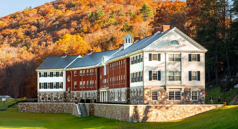 L'edificio storico della Kent School è circondato da fogliame autunnale colorato su una collina.