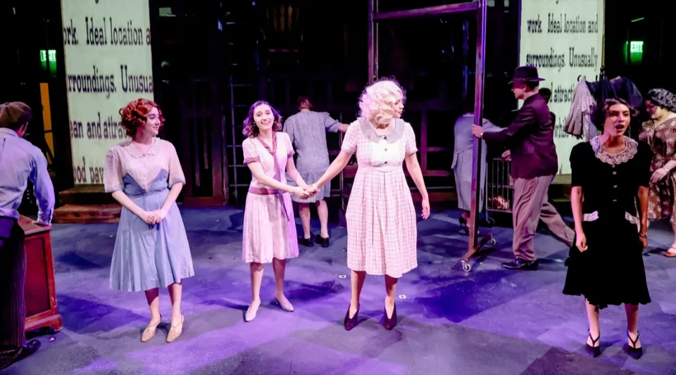 Un gruppo di studentesse, in maggioranza ragazze, si trova sul palco del Ventura County Community College District durante una rappresentazione teatrale.