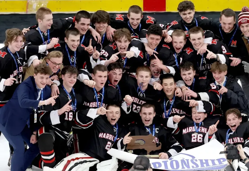 La squadra sportiva della Marblehead High School festeggia insieme in uno spogliatoio.