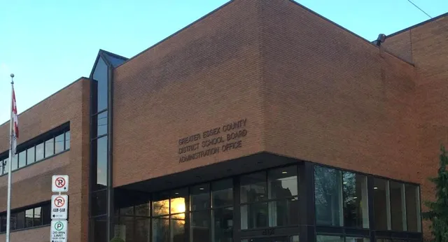 Das große Backsteingebäude mit Glasfenstern des Greater Essex County District School Board vor klarem blauem Himmel.