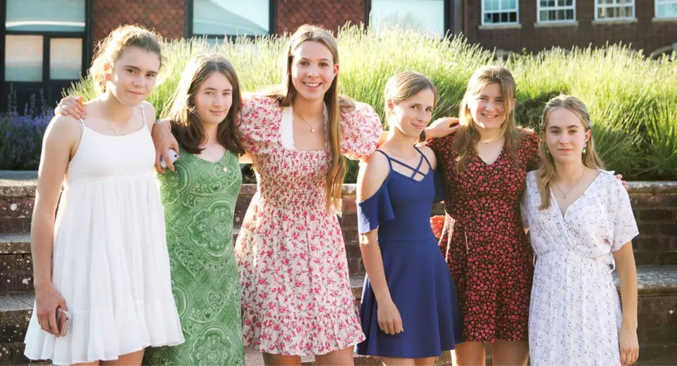 Un gruppo di studentesse si trova davanti a un edificio in mattoni all'interno del campus della Belle River District High School.