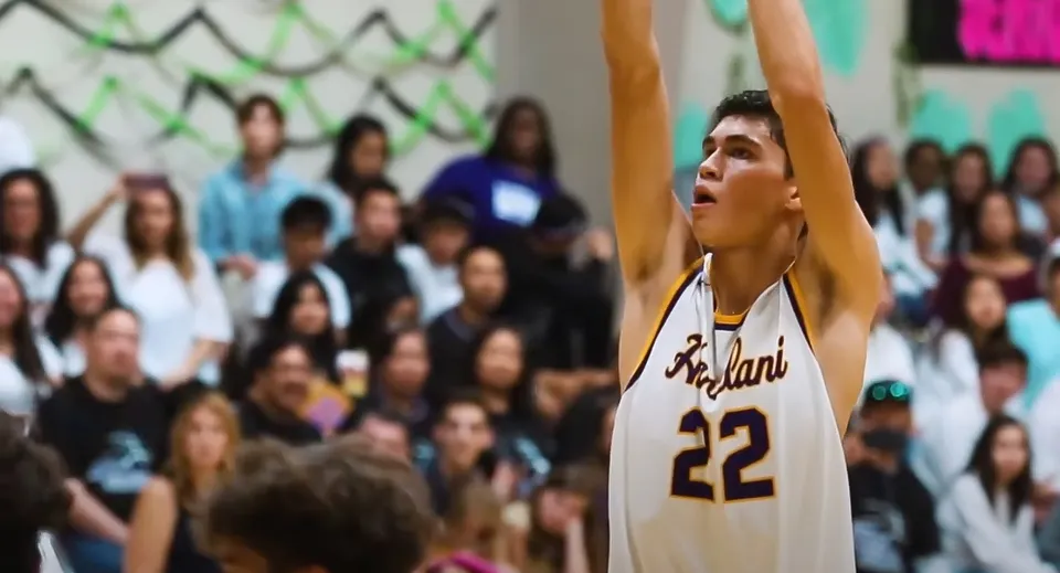 Un giocatore di pallacanestro con una maglia bianca con il numero 22 salta nella palestra della Hanalani Schools.