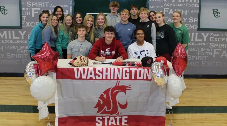 Un gruppo di studenti della Billings Central Catholic High School si riunisce attorno a uno striscione della Washington State University per festeggiare un successo.