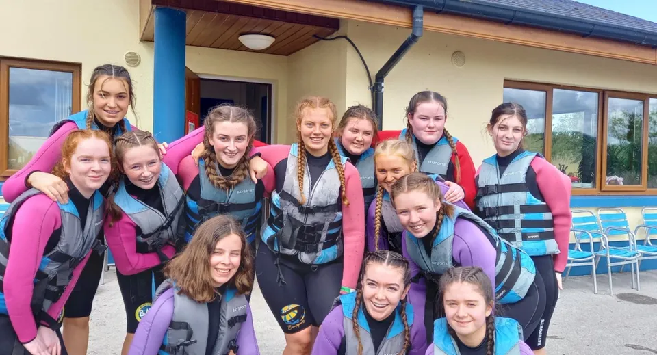 Un gruppo di studentesse dell'Elphin Community College davanti a un edificio in legno durante un'attività all'aperto.