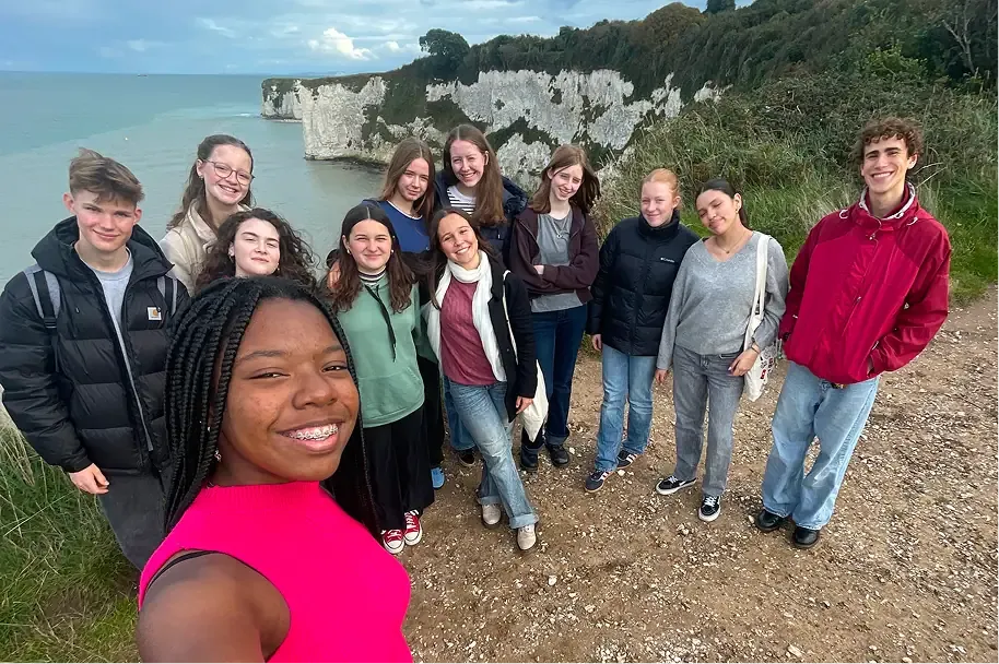 Selfie di gruppo di studenti su una scogliera bianca affacciata sul mare