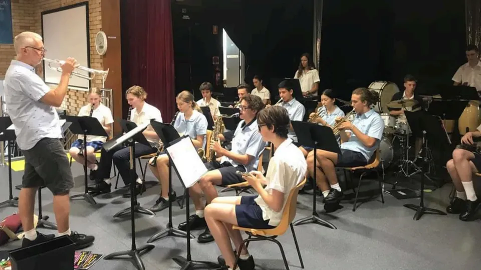 Un insegnante di musica suona la tromba davanti alla banda scolastica della Jannali High School durante le prove.