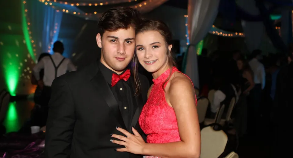 Una giovane coppia si abbraccia durante un evento festivo della Wellington School.