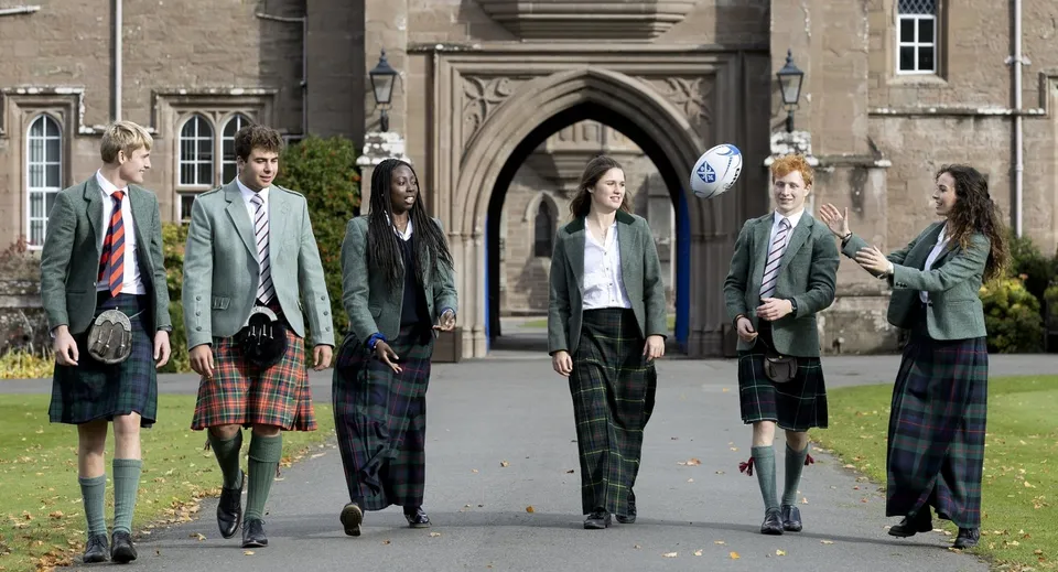 Studenti in uniforme scolastica si trovano davanti all'edificio gotico nel campus del Glenalmond College.