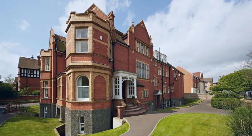 L'edificio storico in mattoni nel campus di Earlscliffe è circondato da un prato ben curato e da una verde vegetazione.