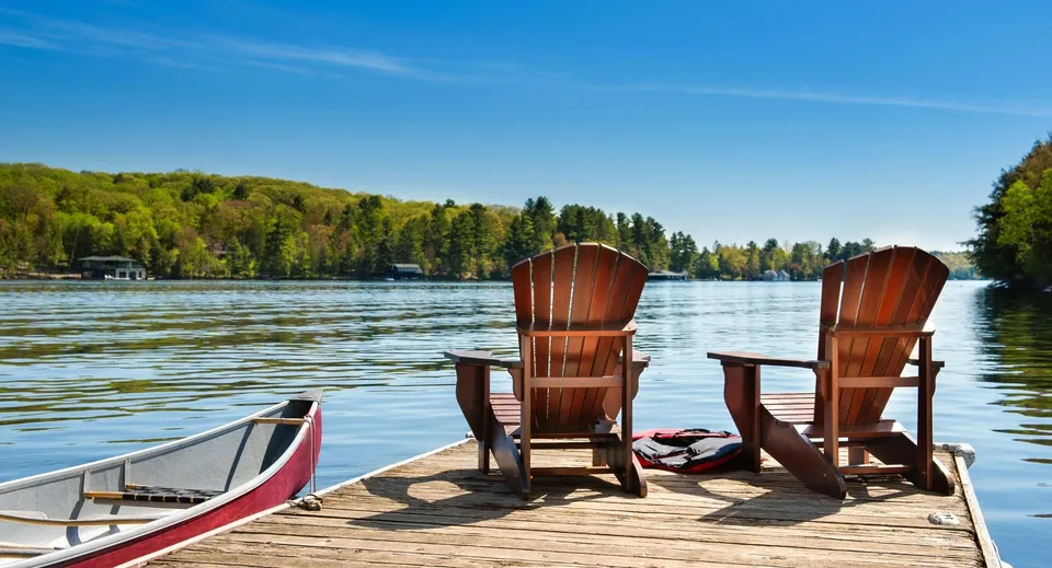 Due sedie di legno si trovano su un pontile al lago nel terreno della Kingsville District High School.