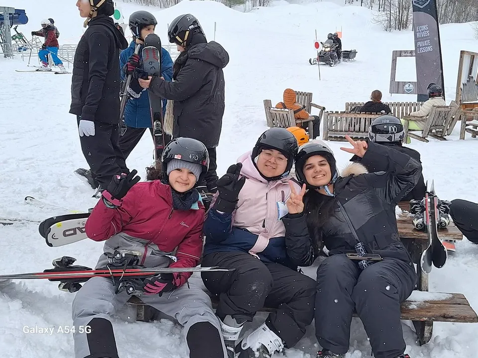 Un gruppo di studenti della École secondaire publique Maurice Lapointe indossa abiti invernali durante una gita sulla neve con attrezzatura da sci.