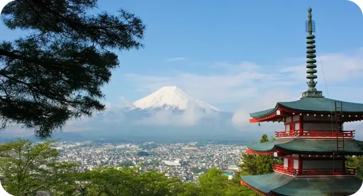Monte Fuji innevato con una pagoda rossa e la città ai suoi piedi, in Giappone