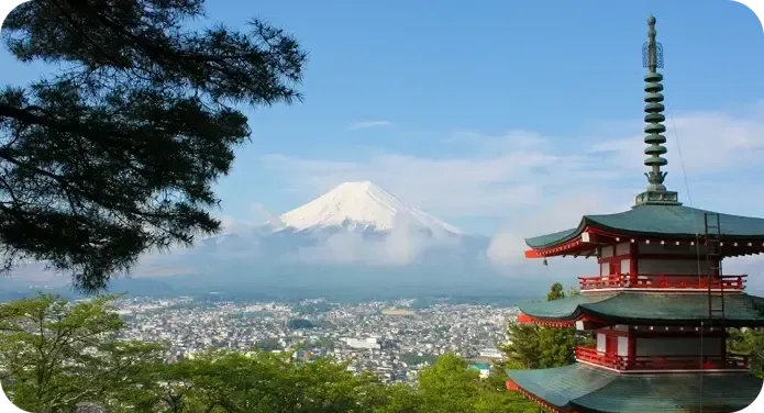 Monte Fuji innevato con una pagoda rossa e la città ai suoi piedi, in Giappone